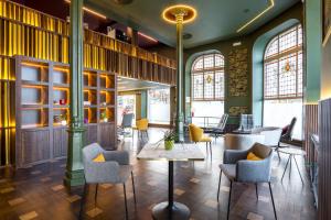 a lobby with chairs and tables and windows at Abba Santander in Santander