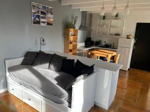 a white couch in a living room with a kitchen at Le Giromagite au pied du Ballon d'Alsace in Giromagny +18 photos