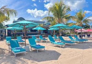 a bunch of chairs and umbrellas on a beach at Platinum Hotel Jimbaran Beach Bali in Jimbaran
