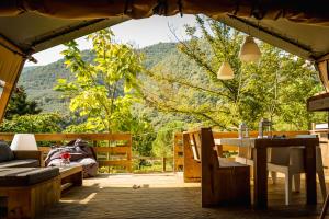 a patio with a table and a view of the mountains at Lodge Holidays - Camping Delle Rose in Case Romagnoni +34 photos