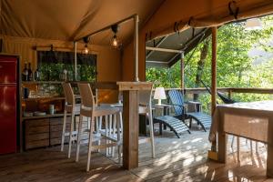 a tent with chairs and a bar on a deck at Lodge Holidays - Camping Delle Rose in Case Romagnoni