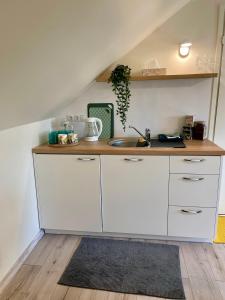 una cucina con mobili bianchi e un lavello di A Studio That Warms the Soul a Tapa