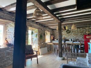 a room with stone walls and tables and chairs at Ta Petrina Cottage in Selishte