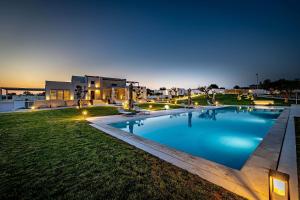 a large swimming pool in a yard at night at Shalamu Luxury Apartments in Rosolini