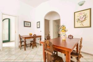 Un comedor con mesa y sillas de madera. en Appartamento Retrò fronte Mare, en Leuca