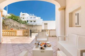 Un patio con una mesa y sillas en un edificio. en Appartamento Retrò fronte Mare, en Leuca