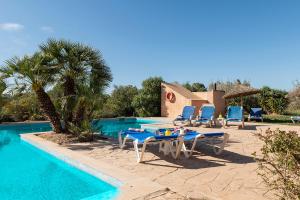 une piscine avec tables et chaises à côté d'un complexe hôtelier dans l'établissement Finca del Corazòn, à Campos