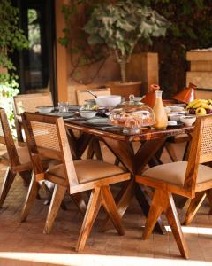 a wooden table with a bowl of food on it at Luxury Resort Loudi Marrakech in Marrakech