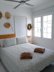 een slaapkamer met een bed met twee bruine handdoeken erop bij Chez Carmen Allegranza - Pool View - By Lanzarote Vacation Homes in Puerto del Carmen