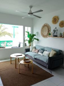 een woonkamer met een blauwe bank en een tafel bij Chez Carmen Allegranza - Pool View - By Lanzarote Vacation Homes in Puerto del Carmen