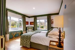 a bedroom with a large bed and windows at Corrib Lodge in Gortnashingaun