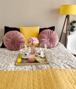 a tray with wine glasses and flowers on a bed at Elite Home 5 Jeżyce- Barańczaka 5 in Poznań
