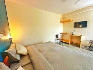 a bedroom with a bed and a desk in it at The Founder's Tribe in Bīr