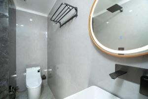 bagno con servizi igienici bianchi e specchio di Hotel Sri Ashvik Rameswaram a Rāmeswaram Altre 16 foto