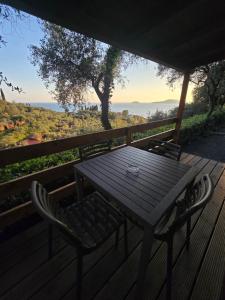 a wooden table and chairs on a deck with a view at Campeggio Gianna Golfo dei Poeti in Lerici