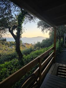a porch with a bench and a view of the ocean at Campeggio Gianna Golfo dei Poeti in Lerici