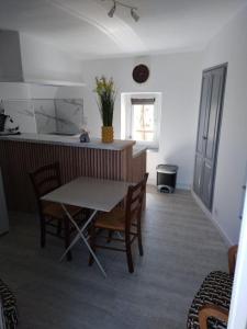 a kitchen with a table and chairs in a room at Le porche in Moissac-Bellevue