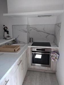 a kitchen with a sink and a stove at Le porche in Moissac-Bellevue