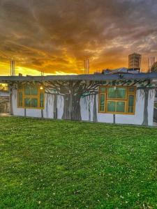 une maison avec un arbre peint sur son côté dans l'établissement The Founder's Tribe, à Bir