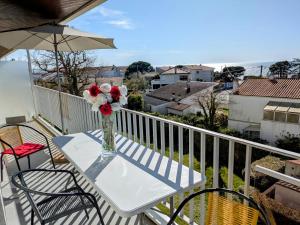 a vase of flowers on a table on a balcony at Appartement Vue Mer 180deg in Saint-Georges-de-Didonne