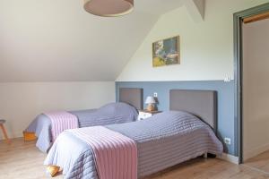 two beds with striped blankets in a bedroom at Le Cheval Blanc - Proche Amiens grand jardin in Damery