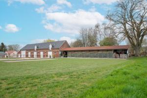 a large building with a grass field in front of it at Le Cheval Blanc - Proche Amiens grand jardin in Damery +4 photos