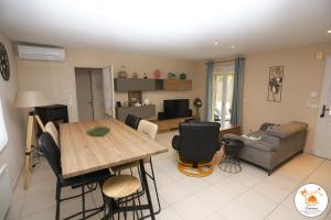 ein Wohnzimmer mit Tisch und Couch in der Unterkunft Saint Cyprien jolie villa avec piscine in Saint-Cyprien