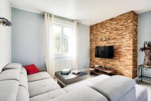 エルキにあるMaison pour 8 avec piscine - 800m de la plageのソファとレンガの壁のあるリビングルーム