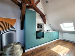 a kitchen with blue cabinets and a microwave at Les Bulles d'Aÿ - Loft in Ay