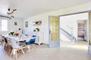 エルキにあるMaison pour 8 avec piscine - 800m de la plageのテーブルと椅子のある白いダイニングルーム