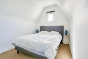エルキにあるMaison pour 8 avec piscine - 800m de la plageの窓付きのベッドがある白い寝室