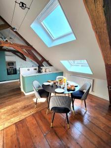 a kitchen with a table and chairs in a room at Les Bulles d'Aÿ - Loft in Ay +10 photos