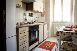 ローマにあるAppartamento Residence Sole e Lunaのキッチン(コンロ、シンク、テーブル付)