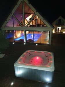 a bath tub sitting in front of a building at La Fontaine - Détente - Piscine Jacuzzi - 12p in La Chartre-sur-le-Loir