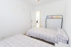 a bedroom with two beds and a mirror at 099 - Parque y playa 007 - comfortHOLIDAYS in Santa Pola +13 photos