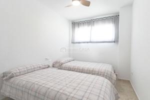 two beds in a white room with a window at 099 - Parque y playa 007 - comfortHOLIDAYS in Santa Pola +13 photos