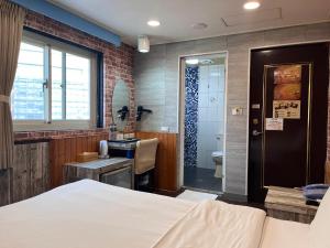新竹市にあるBin Chen Business Hotelのベッドのある寝室と洗面台のある浴室