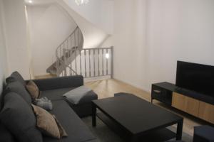una sala de estar con un sofá y una mesa en Escapade en bord de Dordogne, en Bourg-sur-Gironde