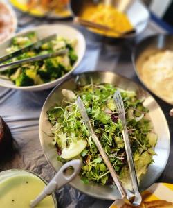 a plate of salad with tongs on a table at Stay Pohang Hotel in Pohang
