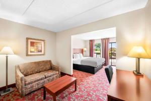a hotel room with a bed and a couch at Quality Inn Selma - Smithfield in Selma +28 photos