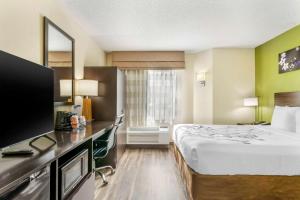 a hotel room with a bed and a television at Sleep Inn Hickory South in Hickory