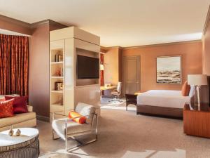 a hotel room with a bed and a living room at Fairmont Chicago Millennium Park in Chicago