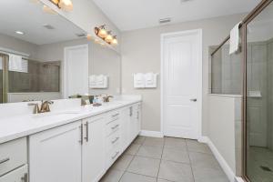 ein weißes Bad mit 2 Waschbecken und einer Dusche in der Unterkunft Marvelous Home With Private Pool And Waterpark & Resort Access Near Disney At Encore Resorts Reunion - 7464Mr in Kissimmee