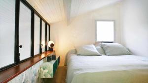 a bedroom with a bed and a large window at Maison entre forêt et océan - piscine et tennis in Ondres +39 photos