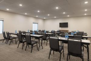 a conference room with tables and chairs and a screen at Holiday Inn Express & Suites Leesburg - Historic District by IHG in Leesburg +101 photos