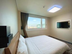 a hotel room with a bed and a window at Stay Pohang Hotel in Pohang