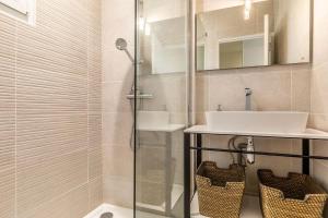 比亚里茨Hôtel Au Bon Coin的带水槽和淋浴的浴室