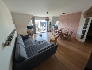 a living room with a couch and a dining room at WimSaens in Wimereux