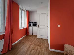 an orange room with a white door and a kitchen at Studio Chic N2 avec Jacuzzi in Roubaix +12 photos