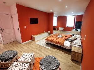 a bedroom with red walls and a bed with ottomans at Studio Chic N2 avec Jacuzzi in Roubaix